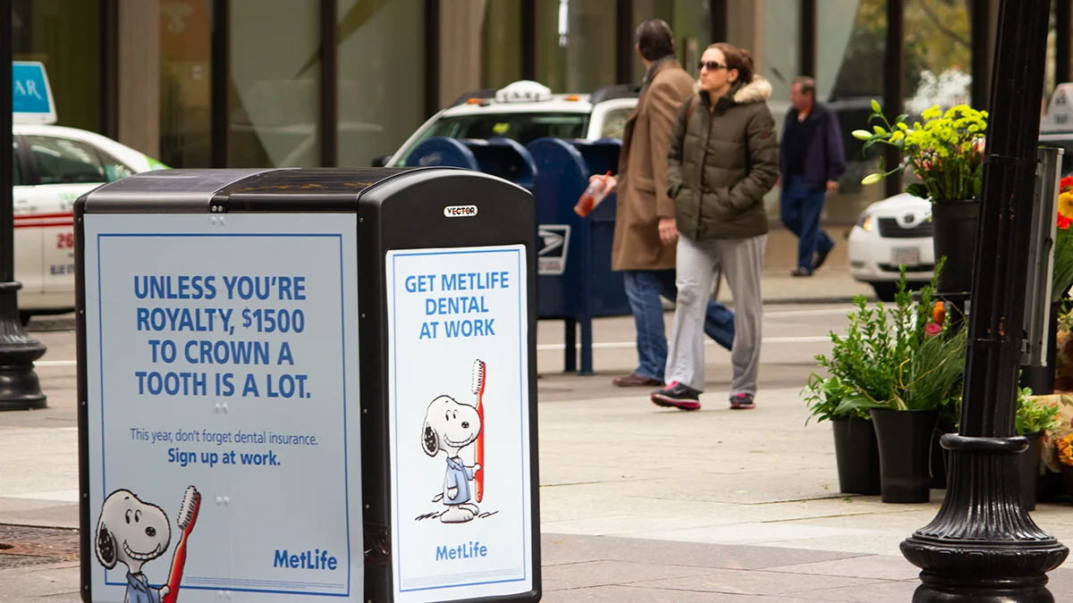MetLife Snoopy dental posters on a city trash can
