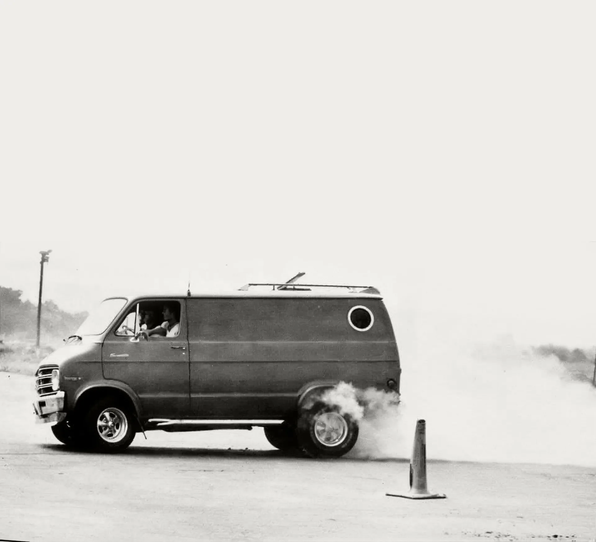 Van doing a burnout, dust cloud behind it